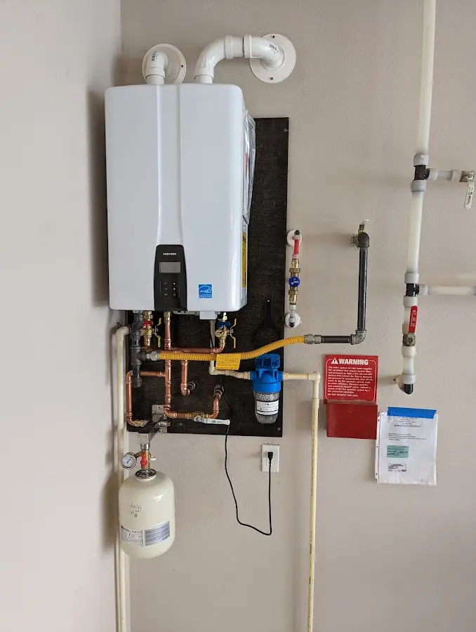 Professional plumber installing copper piping in a Evans home